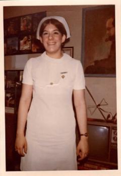 Pamela Marcus smiles in a white nursing outfit with a nursing cap.