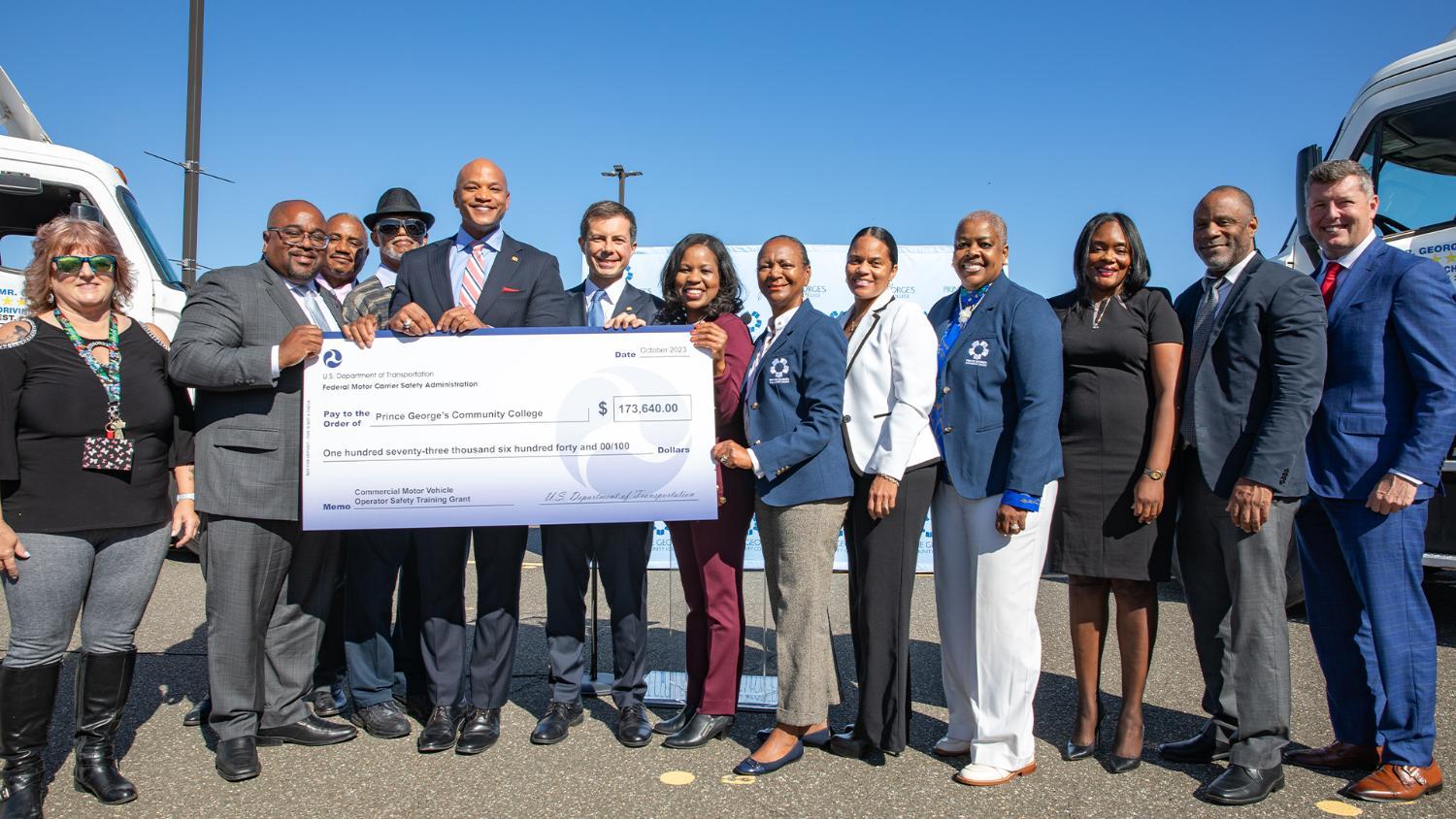 U.S. DOT Secretary Pete Buttigieg and Governor Wes Moore stand with Dr. Sherrie Johnson, Barbara McCreary, James Brackin, Dena Wilson, Chanelle Whittaker, former Representative Patrick Murphy, and others while presenting a grant funding award to PGCC.