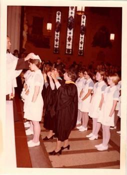 Pamela Marcus (shown left) receiving her cap as a nurse among her graduating class.